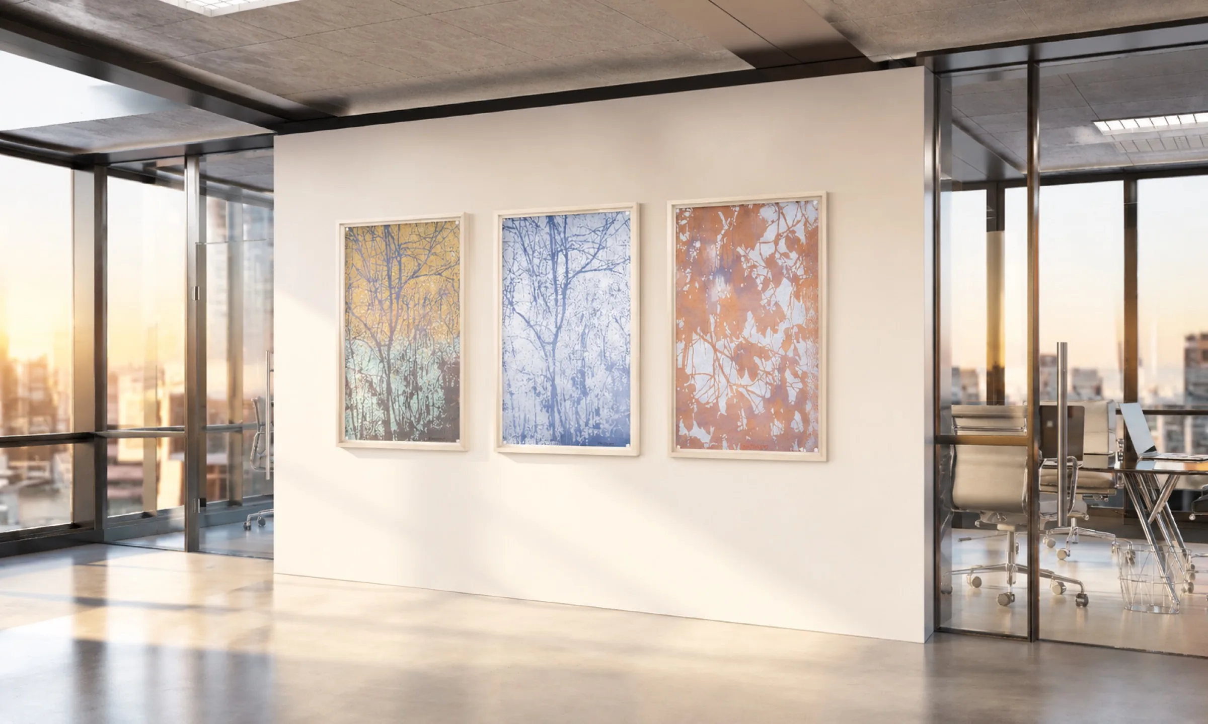 Three framed works by Luca Pancrazzi on a sunlit office wall.